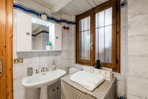 a white bathroom with a sink and a mirror at P&P Borgo Apartment in Bergamo