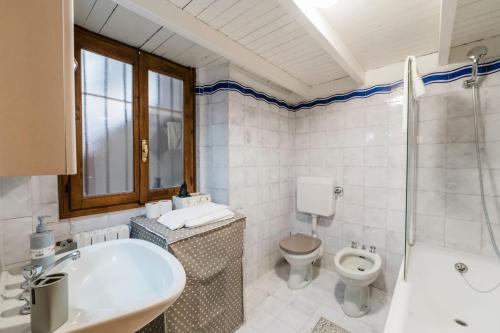 a bathroom with a tub and a toilet and a sink at P&P Borgo Apartment in Bergamo