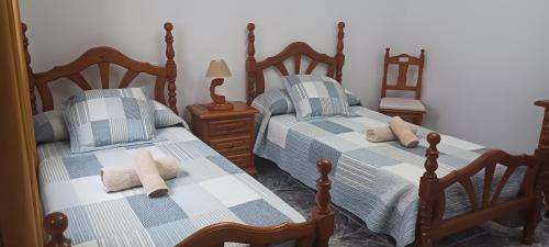 1 Schlafzimmer mit 2 Betten mit blauer und weißer Bettwäsche in der Unterkunft CASA LOS ABUELOS in Puerto del Rosario