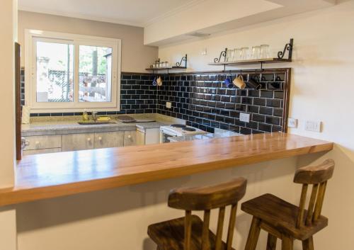 a kitchen with a wooden counter and two stools at donna emilia in Lobos