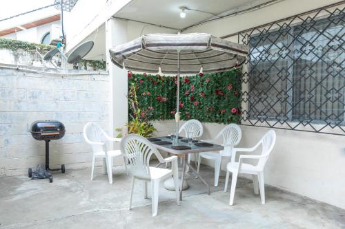 uma mesa e cadeiras e um guarda-sol num pátio em “Casa W-J” Entire flat#1 /Doesn't flood. 2 garages em Guayaquil
