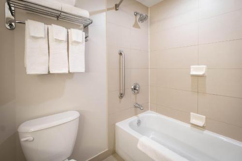 a bathroom with a tub and a toilet and a sink at Holiday Inn Express Kingston Central by IHG in Kingston