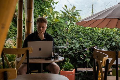 a man sitting at a table with a laptop computer at Viajero Salento Hostel in Salento