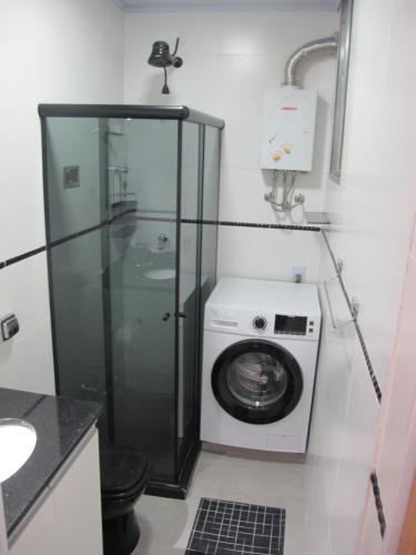 a bathroom with a washing machine and a washer at Apartamento quarto e sala in Rio de Janeiro