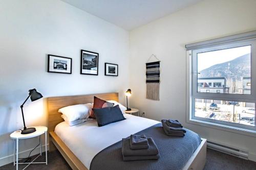 a bedroom with a bed and a large window at Reved Up & Out - Remarkable Two Bedroom Condo in Revelstoke
