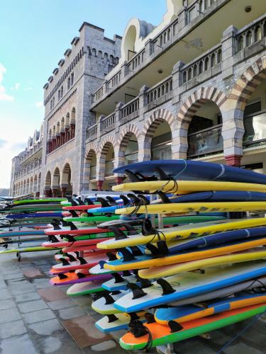 une pile de planches de surf bordées devant un bâtiment dans l'établissement XOKO GORRI, à Urrugne