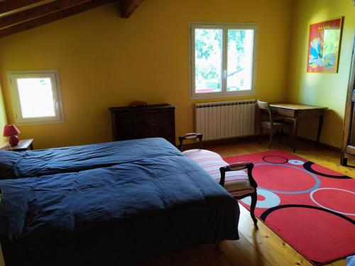 1 dormitorio con cama y alfombra roja en XOKO GORRI, en Urrugne