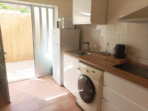 a kitchen with a washing machine and a sink at Cávado Terrace Studio in Parada de Tibães