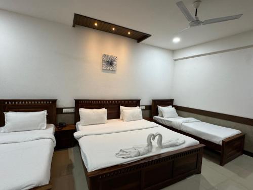 ein Zimmer mit 2 Betten mit Schwänen darauf in der Unterkunft Hotel Tirth by Sonu's in Ujjain