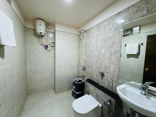 ein Bad mit einem WC und einem Waschbecken in der Unterkunft Hotel Tirth by Sonu's in Ujjain