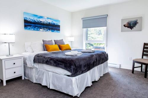 Un dormitorio con una cama grande y una ventana en Revy Pow Pad - Private Hot Tub 3 Bedroom Condo, en Revelstoke