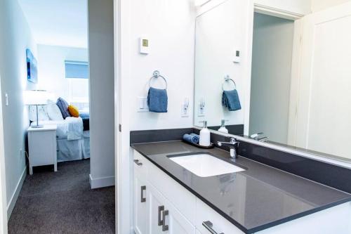 a bathroom with a sink and a mirror at Revy Pow Pad - Private Hot Tub 3 Bedroom Condo in Revelstoke