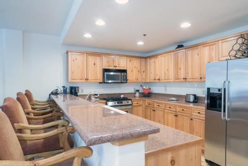 a kitchen with wooden cabinets and a stainless steel refrigerator at Bear Creek Lodge 110A in Telluride