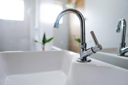 a kitchen sink with two faucets on top of it at Lar do Vinil - Conforto e ótima localização in Nova Petrópolis