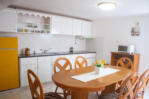 a kitchen with a wooden table and chairs in a kitchen at Vila Paradise Sea & Swimming Pool View in Beirona