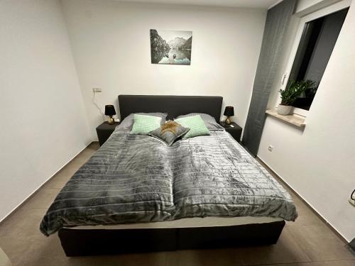 a bedroom with a bed with a gray comforter at Tiny Ferienhaus Greizer Str 26 in Reichenbach im Vogtland