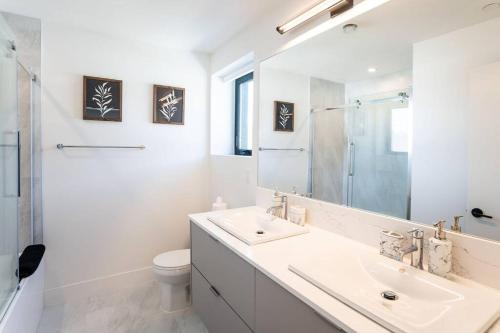 a bathroom with a sink and a toilet and a mirror at Rocky Ridge Getaway - Modern Getaway in Revelstoke in Revelstoke