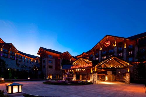 a hotel with a lit up building at night at Sheraton Changbaishan Resort in Fusong