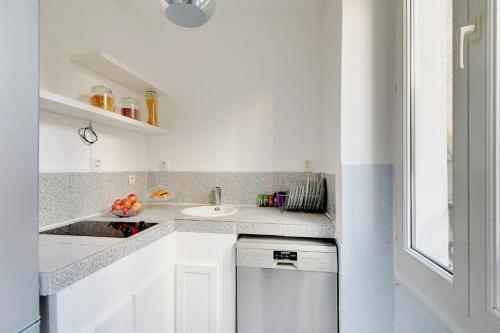 une cuisine blanche avec un évier et un lave-vaisselle dans l'établissement CHAMPS DE MARS - GRENELLE, à Paris
