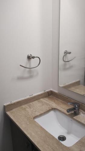 a bathroom with a sink and a mirror at Edificio Núcleo espectacular departamento in Santiago