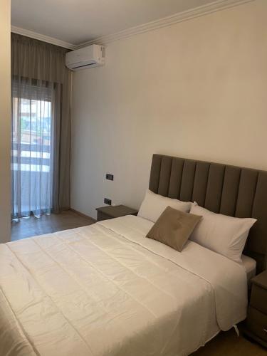 een groot wit bed in een kamer met een raam bij Luxury & cosy apartment in Marrakesh
