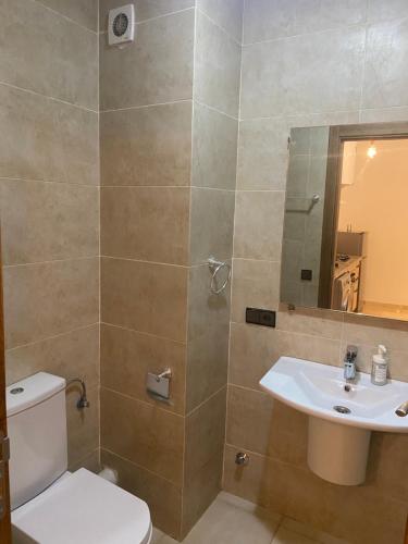 een badkamer met een toilet, een wastafel en een spiegel bij Luxury & cosy apartment in Marrakesh