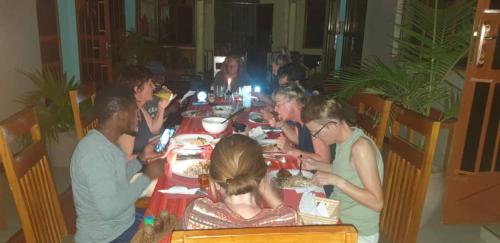 a group of people sitting at a table eating at Kisanga Homestay in Moshi