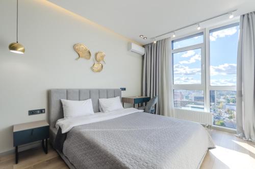 a bedroom with a bed and a large window at 638 Cozy apartment in the residential complex "French Quarter" in Kyiv