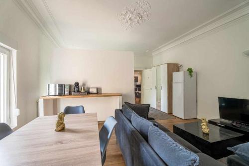 ein Wohnzimmer mit einem Esstisch und einer Küche in der Unterkunft Ch 30m - Salon et kitchenette privé - 2TV - Wifi in Woippy