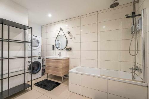 ein Badezimmer mit einer Badewanne, einem Waschbecken und einer Waschmaschine in der Unterkunft Ch 30m - Salon et kitchenette privé - 2TV - Wifi in Woippy