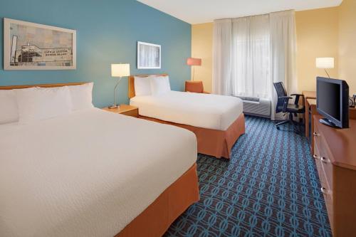 a hotel room with two beds and a flat screen tv at Fairfield Inn & Suites Austin University Area in Austin