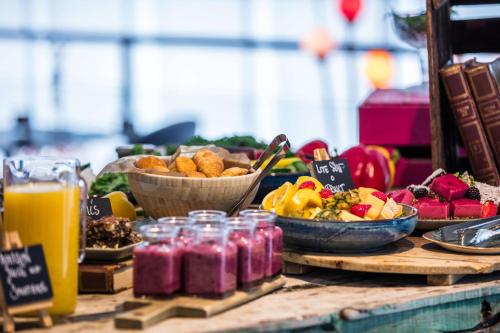 a table with a bunch of fruits and vegetables and juice at Radisson Blu Hotel Uppsala in Uppsala
