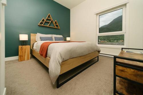 a bedroom with a large bed and a window at The Nest - Condo with Hot Tub & BBQ in Revelstoke