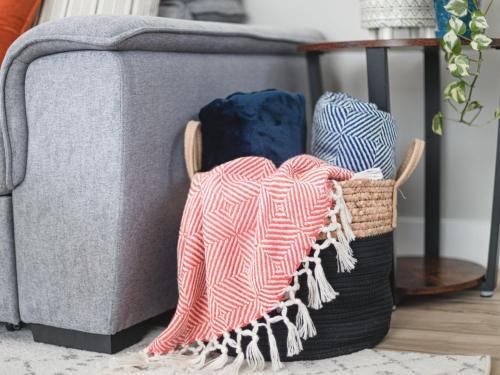 a gray couch with two baskets on a rug at The Mackenzie Haven in Revelstoke