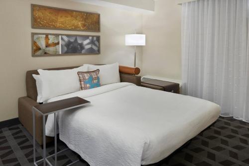 um quarto com uma grande cama branca num quarto em TownePlace Suites by Marriott Oshawa em Oshawa