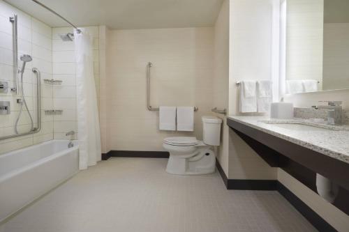 a bathroom with a toilet and a sink and a shower at TownePlace Suites by Marriott Oshawa in Oshawa