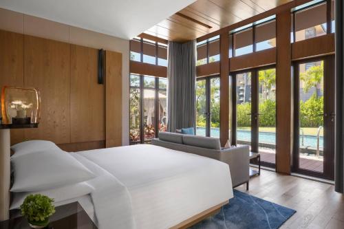 a bedroom with a large white bed and a pool at Xiamen Marriott Hotel & Conference Centre in Xiamen