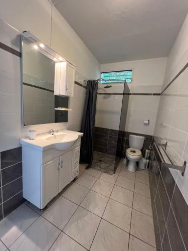 une salle de bain avec un lavabo et des toilettes dans l'établissement Maison type F4 vue sur mer, au Gosier