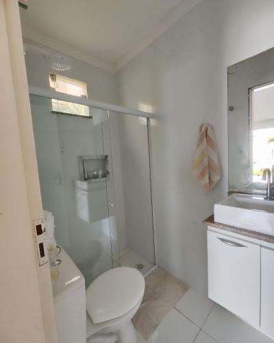 a white bathroom with a toilet and a sink at Casa Lenger in Aracaju