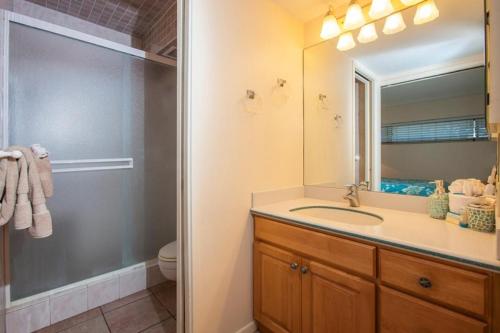 a bathroom with a sink and a shower with a mirror at Sugar Beach 317 - MCH in Kihei