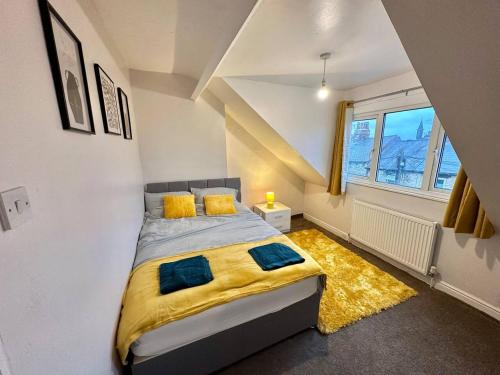 a bedroom with a bed with a yellow blanket and a window at Perfect Group/Contractors Home in Barnsley