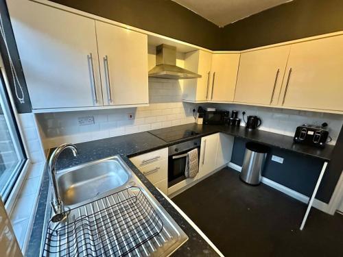 eine Küche mit Spüle und Geschirrspüler in der Unterkunft Perfect Group/Contractors Home in Barnsley