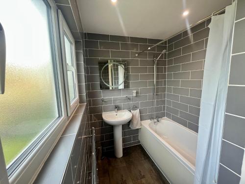 a bathroom with a sink and a bath tub at Spacious 2 double bed city home in Hereford