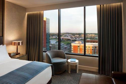 a hotel room with a bed and a large window at The Joseph, a Luxury Collection Hotel, Nashville in Nashville