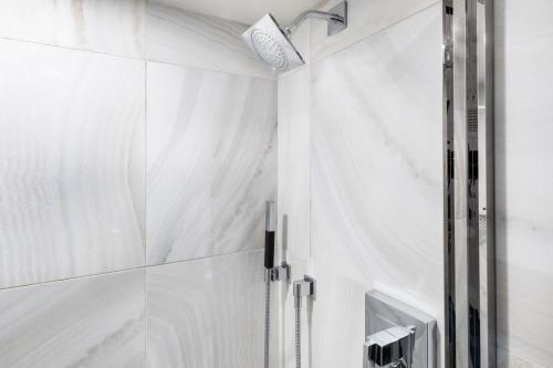 a bathroom with white marble walls and a shower at Pittsburgh Airport Marriott in Robinson Township