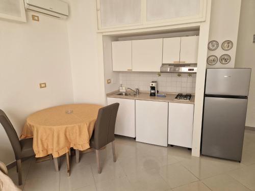 Una pequeña cocina con una mesa y un refrigerador. en Sara House Palermo, en Palermo