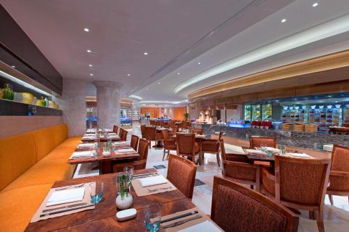 a restaurant with wooden tables and chairs and a bar at Sheraton Grand Wuhan Hankou Hotel in Wuhan
