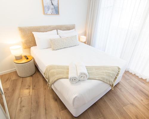 莫羅拉巴海濱的住宿－沙塔拉巴公寓，卧室配有带毛巾的大型白色床
