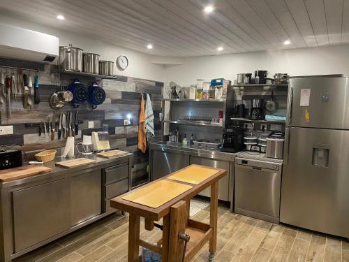 une grande cuisine avec des appareils en acier inoxydable et une table en bois dans l'établissement Grand gîte 14 personnes Sud Vendée, à Saint-Hilaire-des-Loges