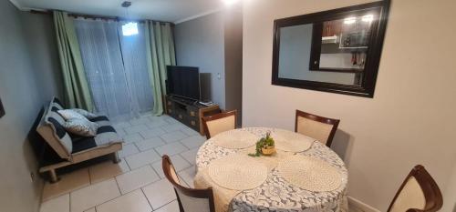 ein Esszimmer mit einem Tisch und einem TV in der Unterkunft departamento Arica verano 2 habitaciones in Arica
